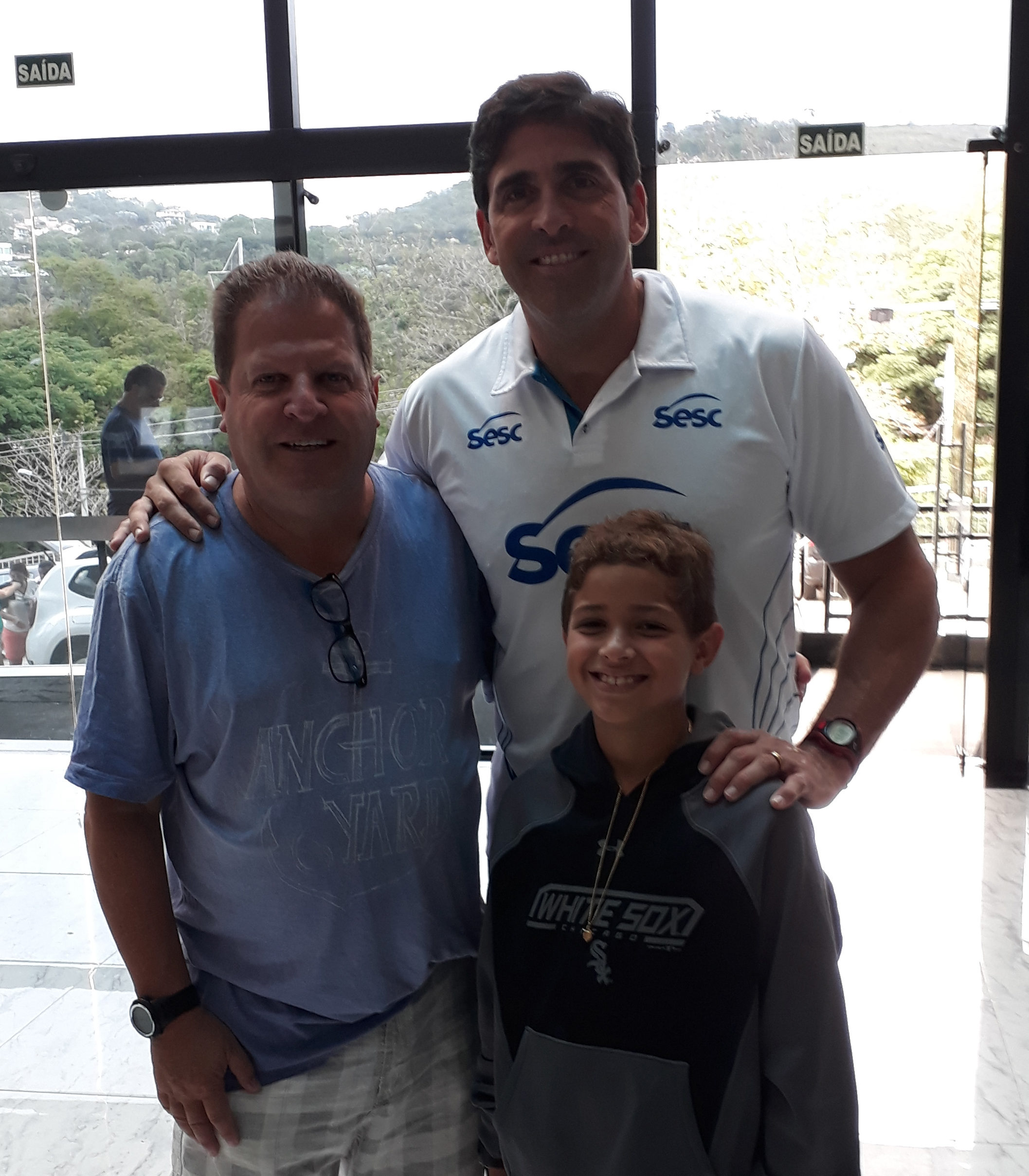 Flávio Villela e o filho Bernardo com Giovane Gávio, que comanda o SESC RJ, aproveitou o jogo com o JF Vôlei para visitar seu primeiro técnico 