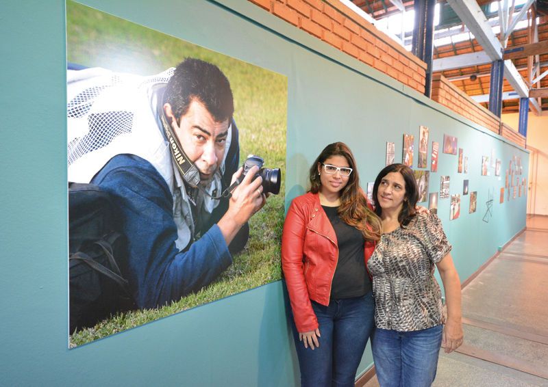 MARCELO RIBEIRO Filha e viúva de Cerezo, Thais e Magdalena posam ao lado de imagem do fotógrafo feita por Humberto Nicoline