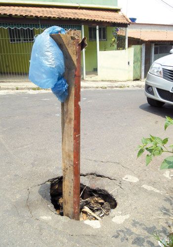 Buraco na pista e bueiro quebrado no São Bernardo 2 Estaca de madeira sinaliza risco na Travessa Nelson Silva