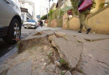 MARCELO RIBEIRO/02-10-14 Na Rua Oscar Vidal, raízes de árvore já cortada levantaram calçamento. A fluidez fica comprometida, além de favorecer quedas