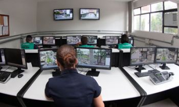 Cada monitor tem a sua frente um telão com um número específico de câmeras a serem acompanhadas. Quando uma ação suspeita é identificada, um policial militar é informado