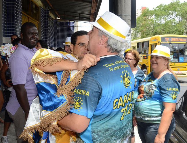 Integrantes de abraçam na frente da sede
