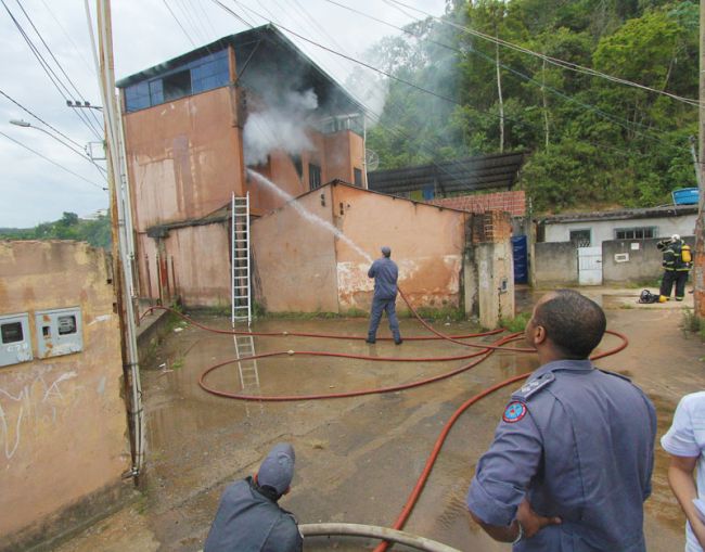 Bombeiros trabalham para apagar as chamas, que atingiram segundo andar do imóvel