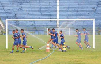 MARCELO RIBEIRO/05-01-15 Antes da chuva, atletas correram entre os aspersores que regavam o gramado do Estádio