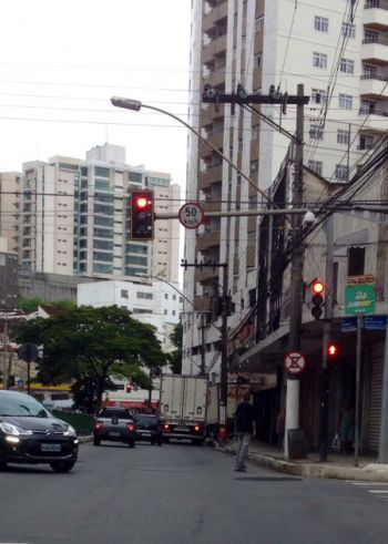 JULIANA DUARTE Jovem passa no sinal vermelho na Avenida Itamar Franco, enquanto o outro faz uma