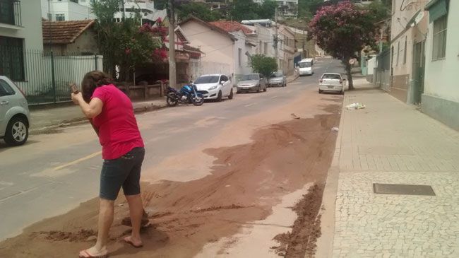 EDUARDO MAIA Moradora da Rua Princesa Isabel retira a areia em frente ao seu prédio