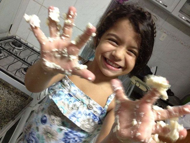 FOTOS ARQUIVO PESSOAL Ana Laura ajuda sua mãe na cozinha e guarda dinheiro para ajudar o próximo