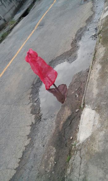 Moradores improvisaram uma sinalização  no buraco da Rua Azul, no Milho Branco