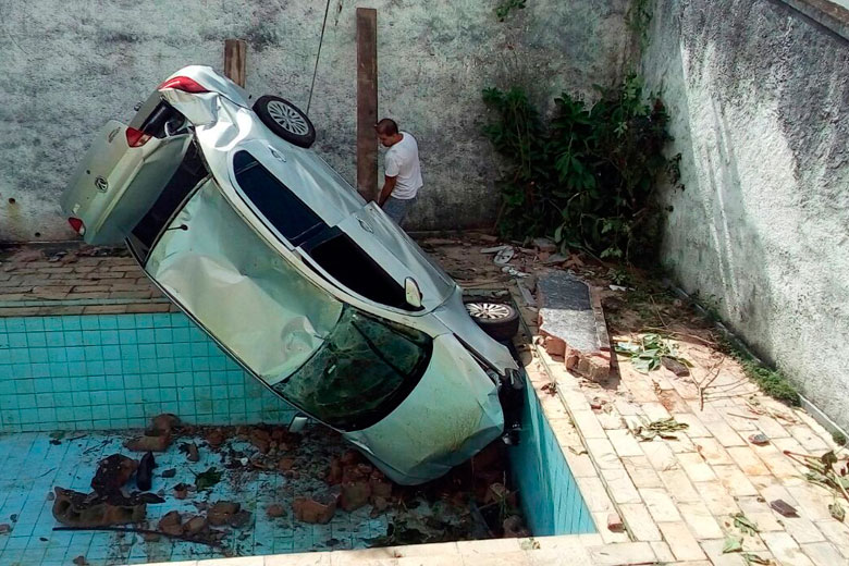 Dois funcionários trabalharam na retirada do veículo que caiu dentro de uma piscina (Foto: Leonardo Costa)