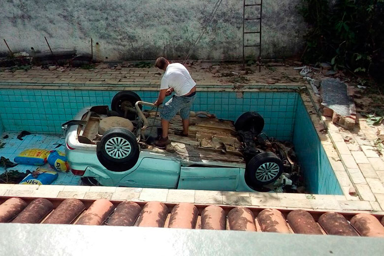 Dois funcionários trabalharam na retirada do veículo que caiu dentro de uma piscina (Foto: Leonardo Costa)