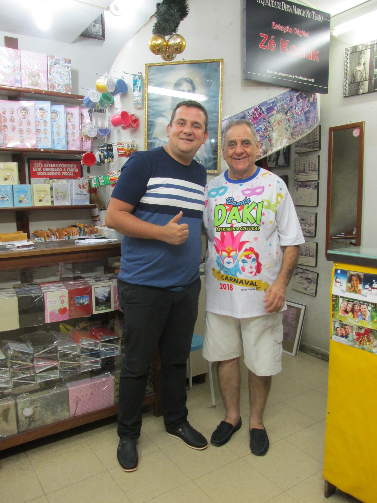 O padre Pierre Cantarino e José Carlos Passos, na Loja do Zé Kodak 1 O padre Pierre Cantarino e José Carlos Passos, na Loja do Zé Kodak, num bate-papo sobre o desfile da Banda Daki