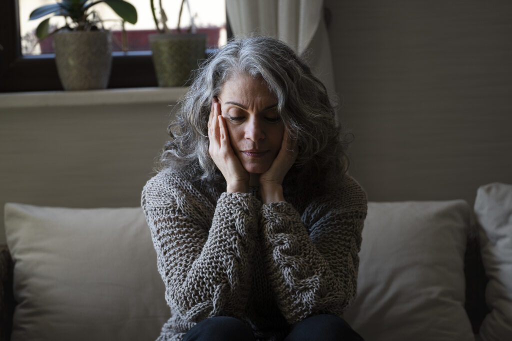 sad elder woman on the sofa