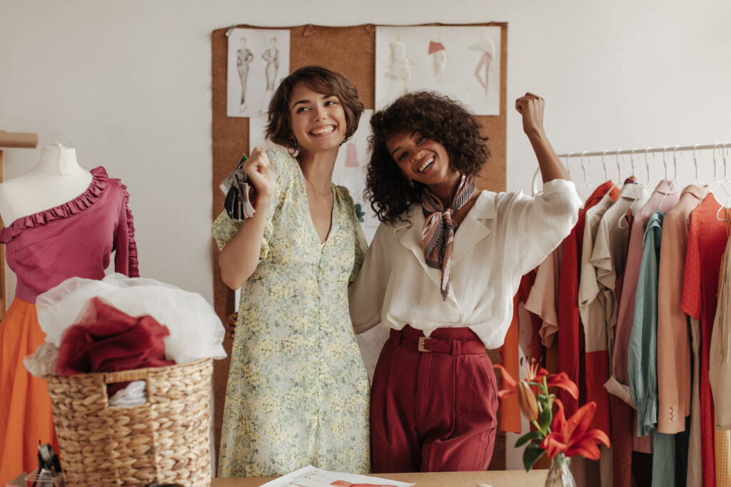 cool young ladies pose near mannequin in office of fashion designer