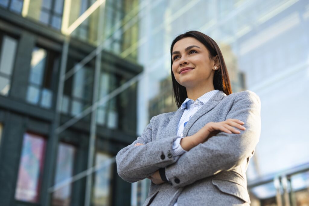 low angle businesswoman posing with arms crossed city