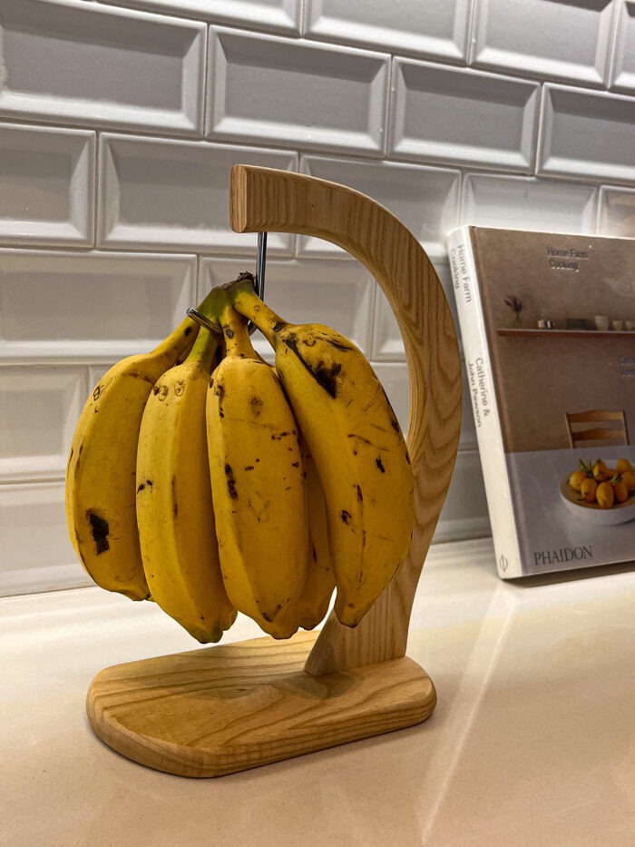 Suporte em madeira clara com design moderno para pendurar bananas 