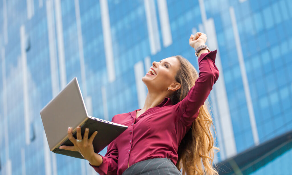 empresaria e a vencedora do acordo entre empresas da cidade mulher de cabelo comprido e a profissional ela esta segurando laptop e rindo muito