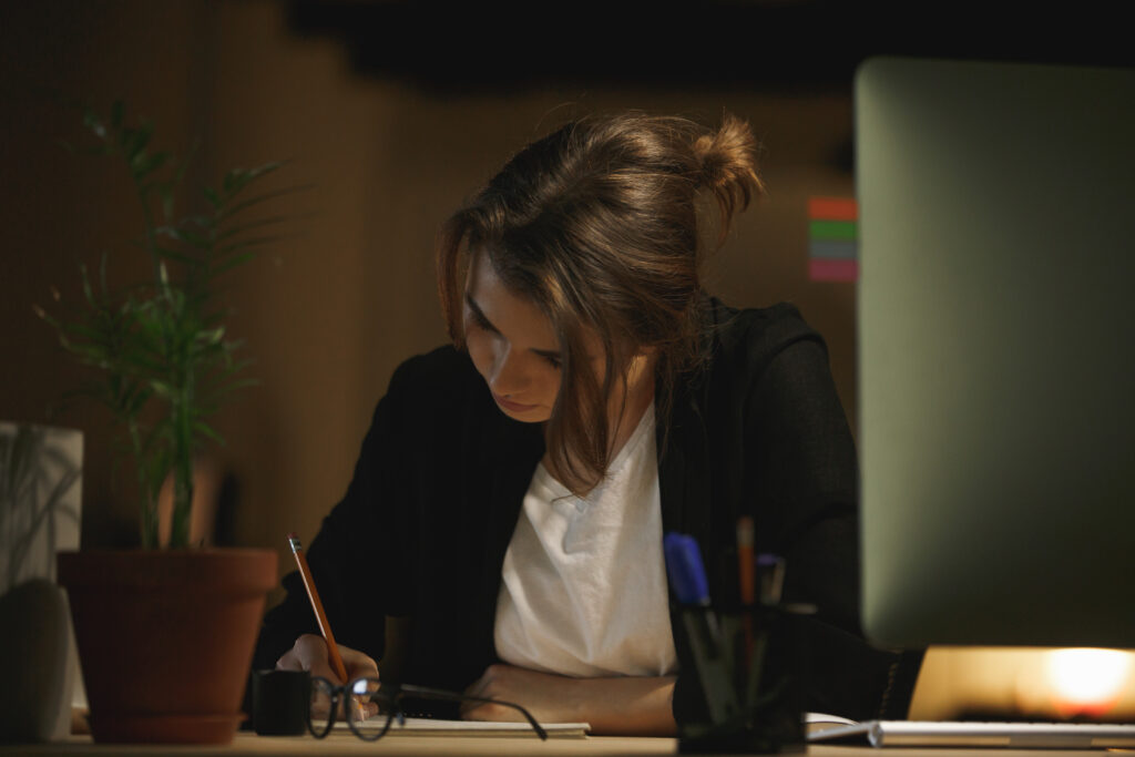 concentrated young lady designer sitting office