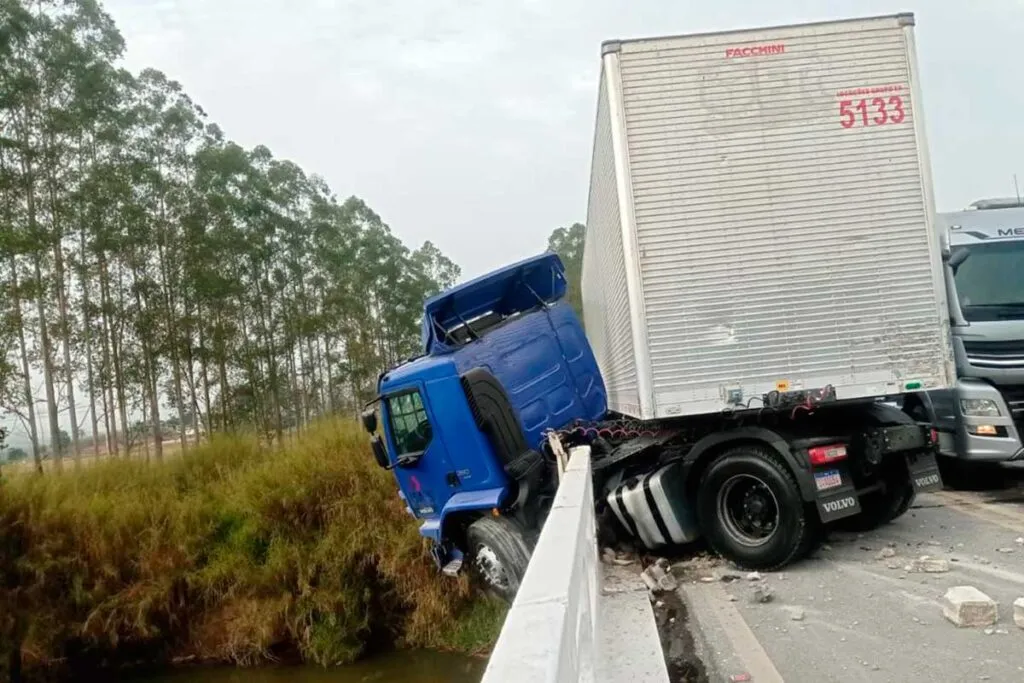 Carreta com produtos de site de compras fica pendurada em ponte na BR-267
