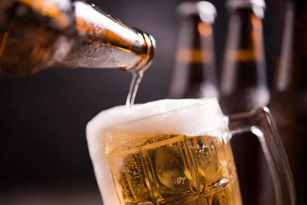 garrafas de vidro de cerveja com vidro e gelo no fundo escuro