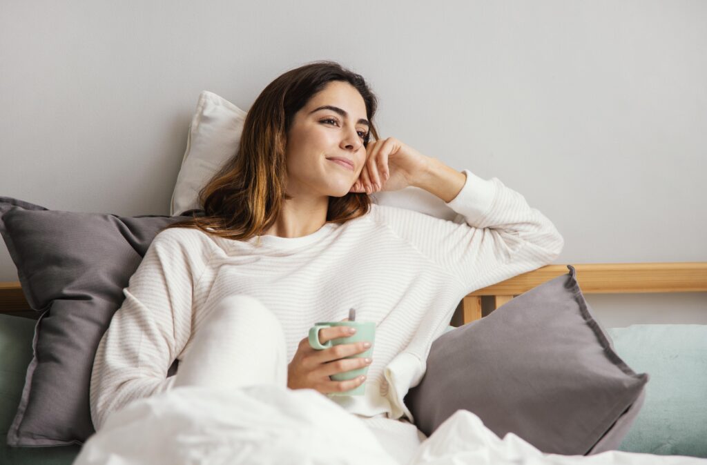 smiley woman having coffee bed