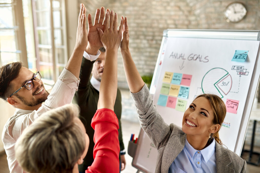 happy business team with raised hands celebrating their success office