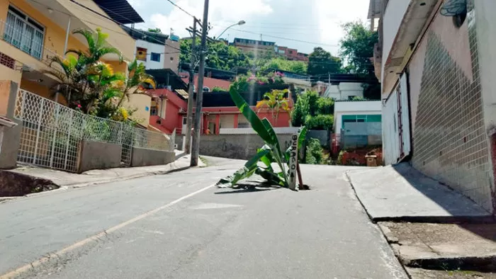 Placa e folhas de bananeira sinalizam buraco no Linhares 1 VU Linhares