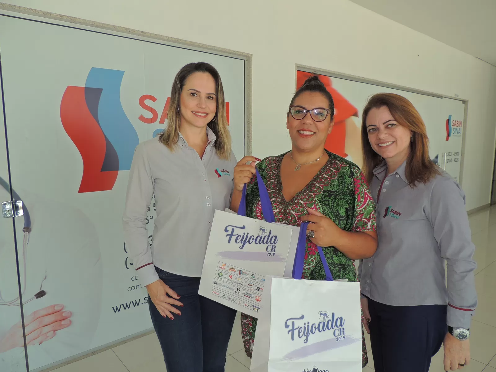 Sábado, dia de feijoada 1 Cláudia Teixeira e Andréa Poggianella ladeando Diana Pires, contemplada com duas camisetas da Feijoada 2019 na promoção do Instagram do Sabin Sinai, que teve mais de três mil comentários